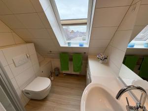 a bathroom with a toilet and a sink and a window at Achterdeck Kajüte in Dornumersiel