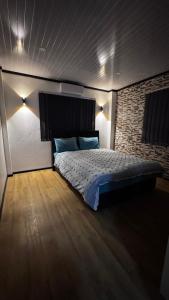 a bedroom with a bed and a brick wall at Raza villa in Lautoka