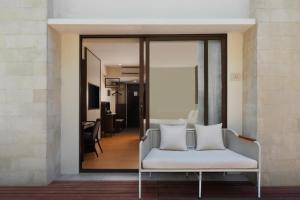 a room with a white couch and a mirror at Aston Kuta Hotel and Residence in Kuta