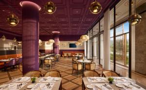 a restaurant with tables and chairs and purple ceilings at Vivanta Ekta Nagar in Kevadia