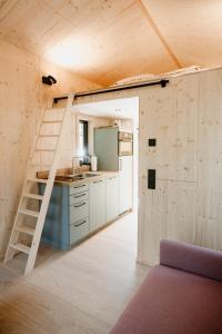 a small kitchen with a staircase in a tiny house at Tiny Chalet in Blankenburg