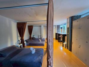 a bedroom with two beds and a large window at Nahm Khao Sok Hostel and Camping in Khao Sok National Park +42 photos