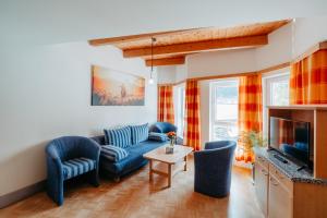 a living room with a couch and chairs and a tv at Landhaus Zitz in Ranten