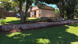 a house with a tree in the yard at Mambo Number Five in Entebbe