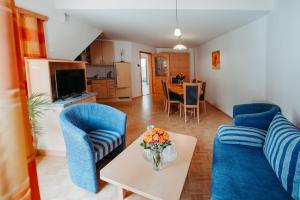 a living room with two blue chairs and a table at Landhaus Zitz in Ranten