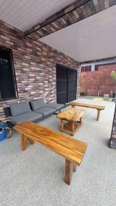 a patio with two wooden tables and a couch at Raza villa in Lautoka