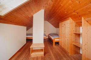 a room with wooden ceilings and a room with a bed at Landhaus Zitz in Ranten