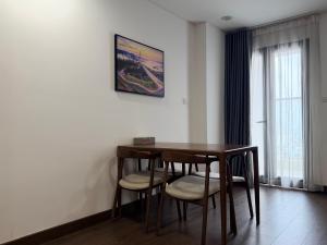 a dining room table and chairs with a picture on the wall at Ha Long 2BR Apartment - Spacious & Modern - Near Center in Ha Long
