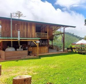 a house with a green lawn in front of it at Rancho Ecojoya Paradise Mountain working farm in nature in San Isidro de El General