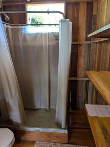 a bathroom with a shower with a shower curtain at Rancho Ecojoya Paradise Mountain working farm in nature in San Isidro de El General +64 photos
