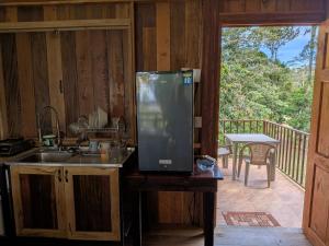 a kitchen with a sink and a refrigerator on a porch at Rancho Ecojoya Paradise Mountain working farm in nature in San Isidro de El General