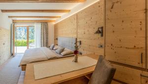 a bedroom with a bed and a wooden wall at Arbea Apartments in Ortisei