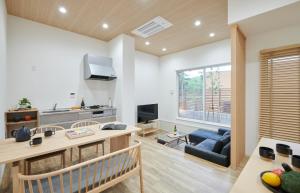 a kitchen and living room with a blue couch at 森のRetreat -foresta di luce- in Hatsukaichi