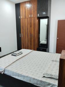 a bedroom with a bed with a dresser and a mirror at Relaxing Villa in Mysuru! in Mysore