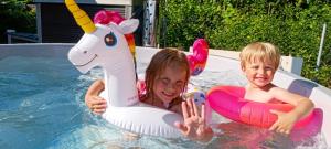 a girl and boy in a pool with an unicorn toy at Umberto Apartamenty Dwupoziomowe Dąbki in Dąbki