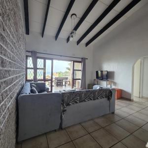 a living room with a couch and a brick wall at Allesreg Holiday Home in Margate