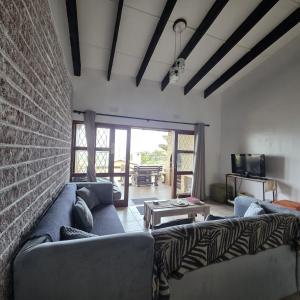 a living room with a couch and a brick wall at Allesreg Holiday Home in Margate
