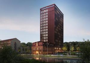 ein hohes rotes Gebäude vor einem Gebäude in der Unterkunft Quality Hotel The Book in Göteborg