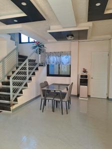 a dining room with a table and chairs and a staircase at Rweydz Guest Inn in Tagbilaran City +12 photos