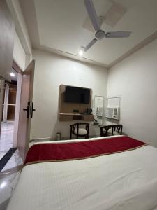 a bedroom with a bed and a flat screen tv at A One Residency in Bahora