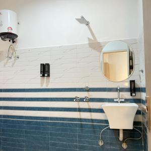 a bathroom with a sink and a mirror at A One Residency in Bahora +6 photos