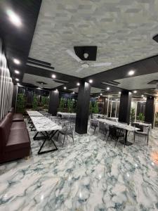 a dining room with tables and chairs on a marble floor at A One Residency in Bahora