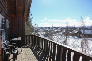 a balcony with two chairs and a view of the snow at Haugsynlies sjarm in Beitostøl