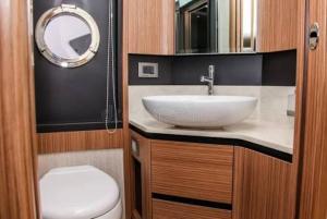 a bathroom with a sink and a toilet and a mirror at HASERO Composites in Kampala