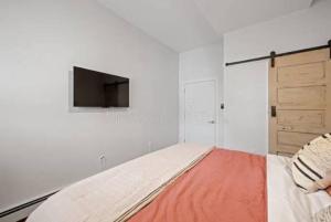 a bedroom with a bed with a tv on the wall at HASERO Composites in Kampala