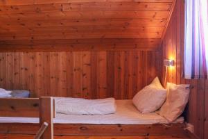 a bed in a room with a wooden wall at Haugsynlies sjarm in Beitostøl