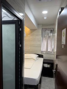 a small bedroom with a bed and a window at Mabuhay INN in Hong Kong