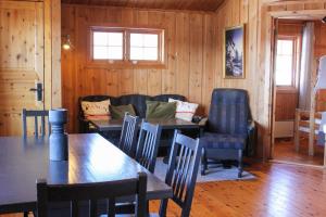 a dining room with tables and chairs and a couch at Haugsynlies sjarm in Beitostøl