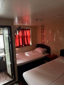 a small room with two beds and a window at Mabuhay INN in Hong Kong +25 photos