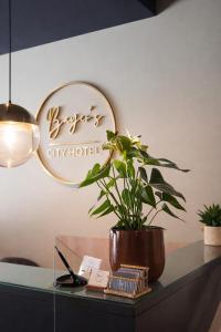 a potted plant sitting on a desk with a mirror at Bayer's City Hotel in Munich