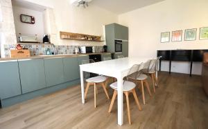 a kitchen with a white table and chairs at The Monet in Châteauneuf-sur-Charente +14 photos