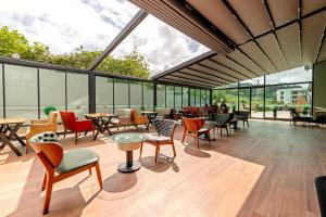 a large room with tables and chairs and windows at Air Barbaros Hotel Trabzon in Trabzon