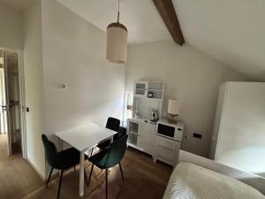 a kitchen with a table and chairs in a room at D'r Preëksjtool in Eygelshoven