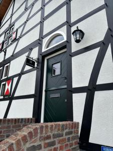 a green door on the side of a building at D'r Preëksjtool in Eygelshoven
