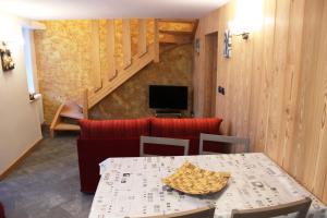 a dining room with a table and a television at Maison Leveque in Brusson