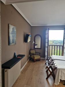 a living room with a table and a balcony at Hotel Colegiata in Santillana del Mar