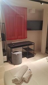 a room with a bed with a desk and a red curtain at Affittacamere gold 5 in Barletta