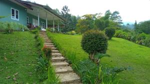 a garden with a stone path in front of a house at Villa Kay View in Sampal 2