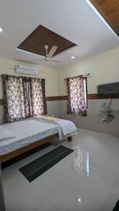 a bedroom with a bed and two windows at SJ Residency in Dharmastala