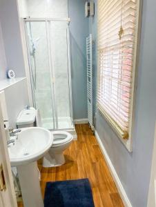 a bathroom with a toilet and a sink and a shower at Cosy Townhouse in Central Leamington with parking in Leamington Spa