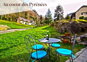a table with chairs and a bottle of wine at Apt 4 Eaux-Chaudes proche Laruns et Espagne in Laruns