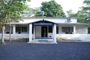 a white house with a sign on the front of it at Silk Estates Madai in Khāpa