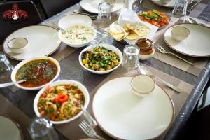 a table with plates and bowls of food on it at Silk Estates Madai in Khāpa