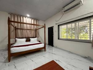 a bedroom with a bed in a room with a window at Silk Estates Madai in Khāpa