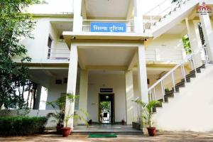 a white building with a blue sign on it at Silk Estates Madai in Khāpa