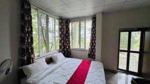 a bedroom with a large white bed with windows at Silk Estates Madai in Khāpa